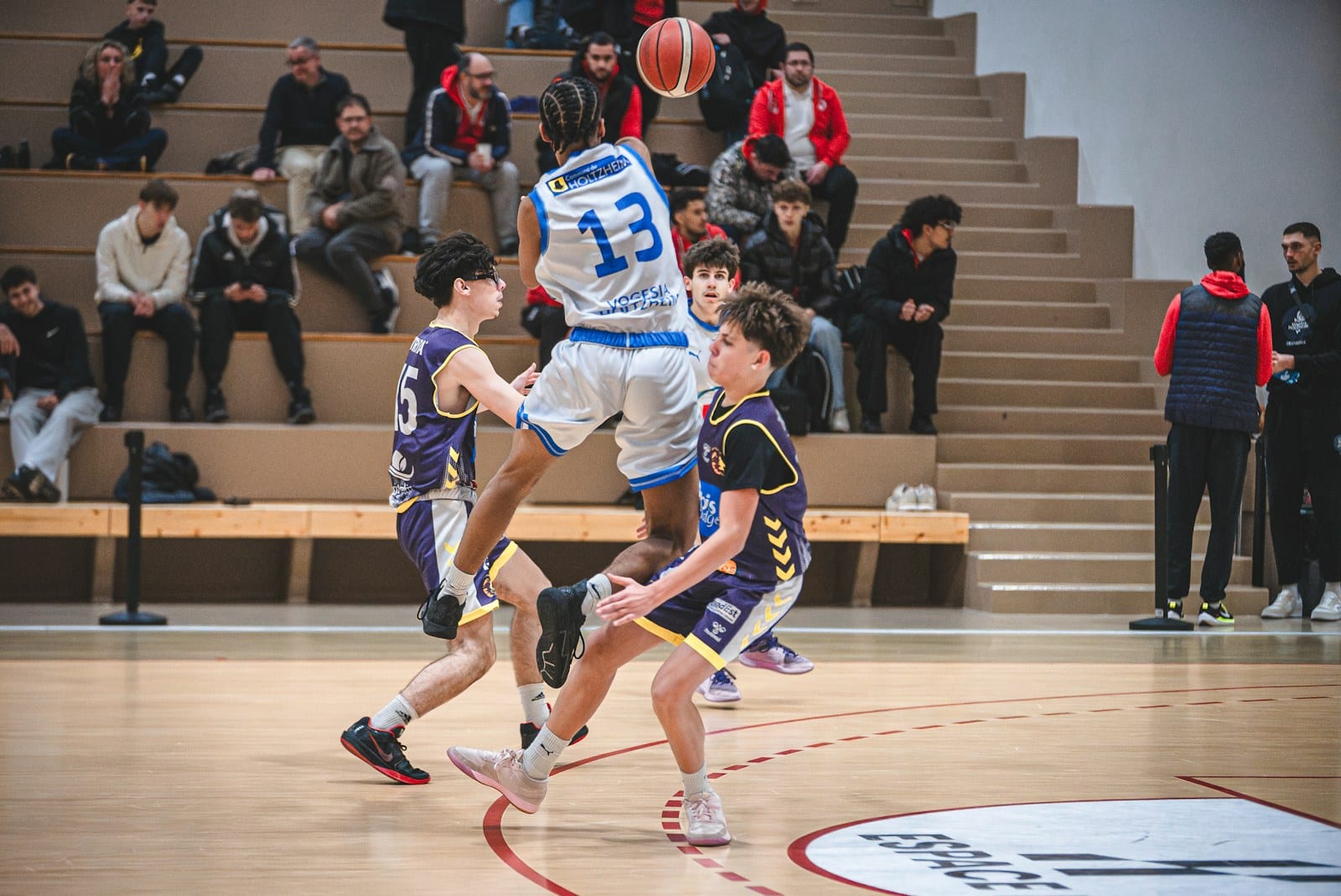 Basketball players competing in action during an indoor arena game