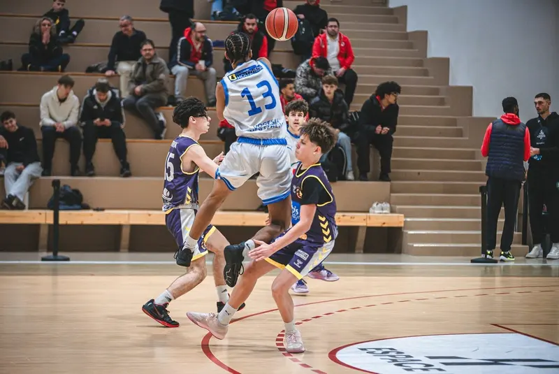 Basketball players competing in action during an indoor arena game